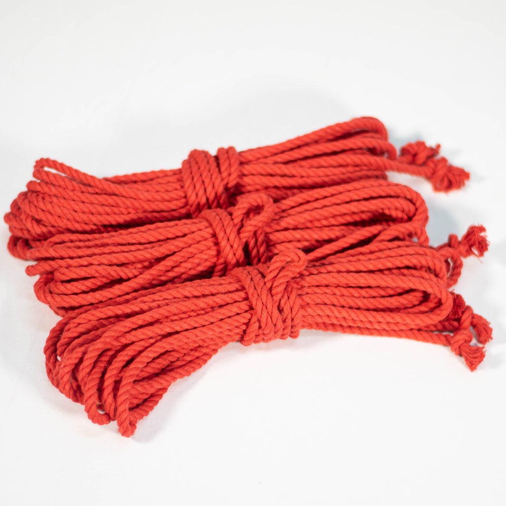 3 coiled red cotton ropes with knots on the end, displayed on a white background.